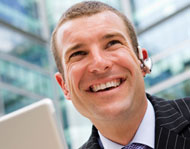 Man with laptop and earpiece - Unified Communications